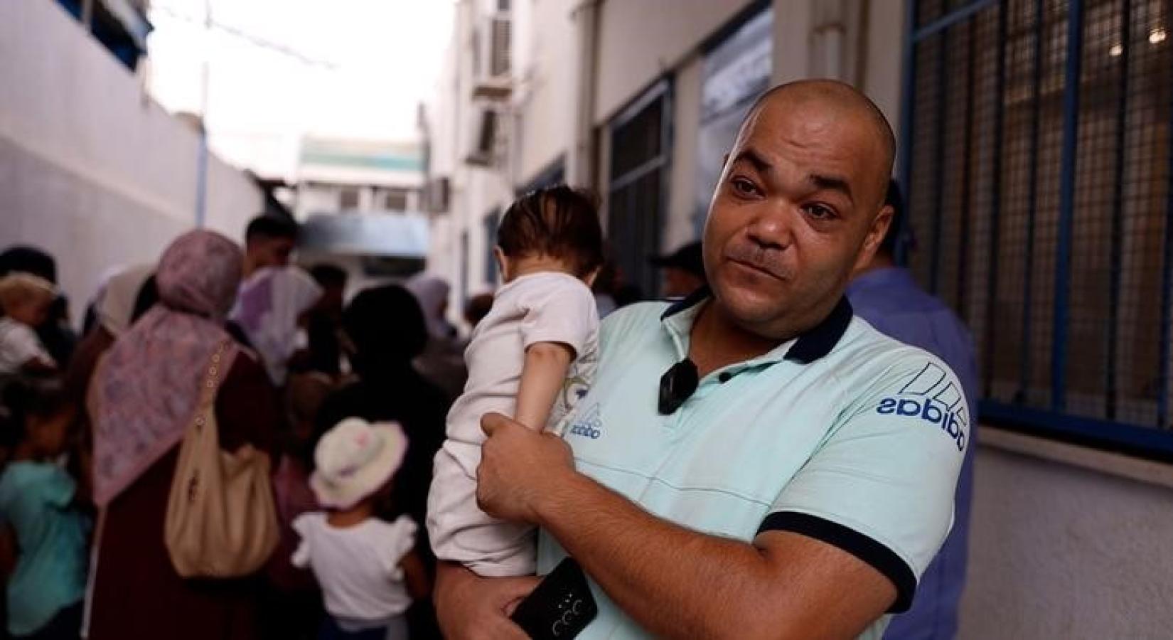 A man holds her baby daughter.