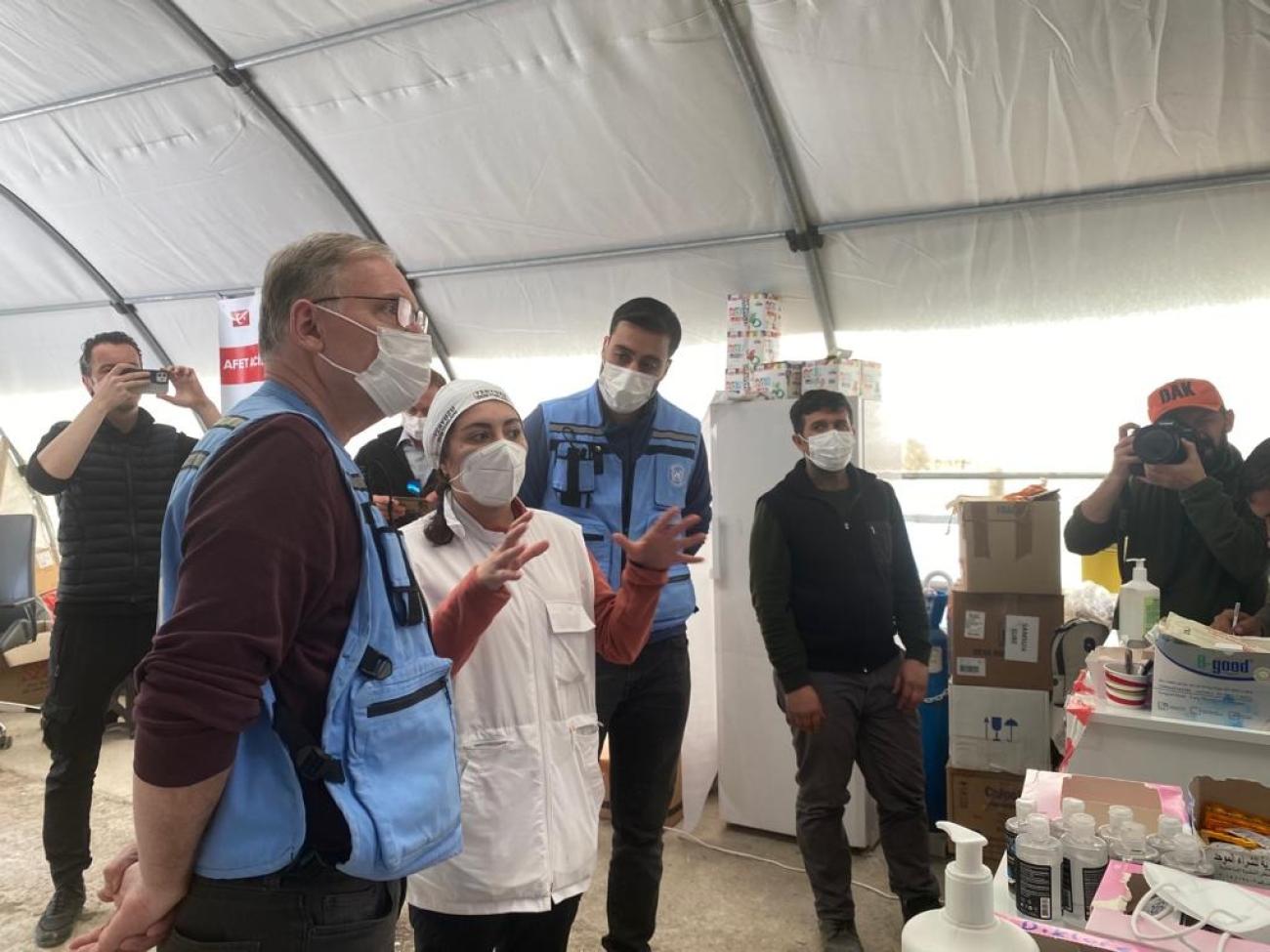 UN RC speaking to health personnel inside a health tent in the earthquake area