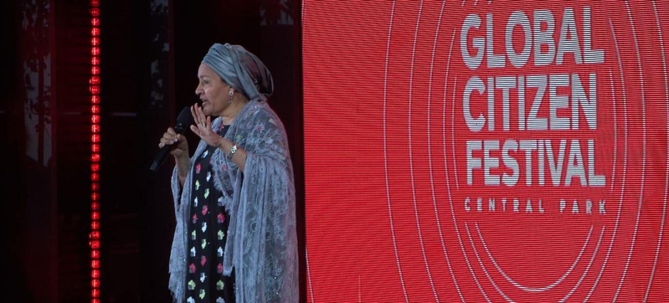Genel Sekreter Vekili Amina Mohammed Global Citizen Festival yazan arkaplanın önünde ayakta konuşuyor.
