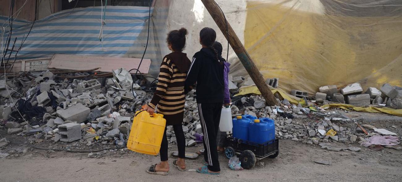 Gazzeli çocuklar su arayışında harabeye dönmüş binaların arasından geçiyor. 