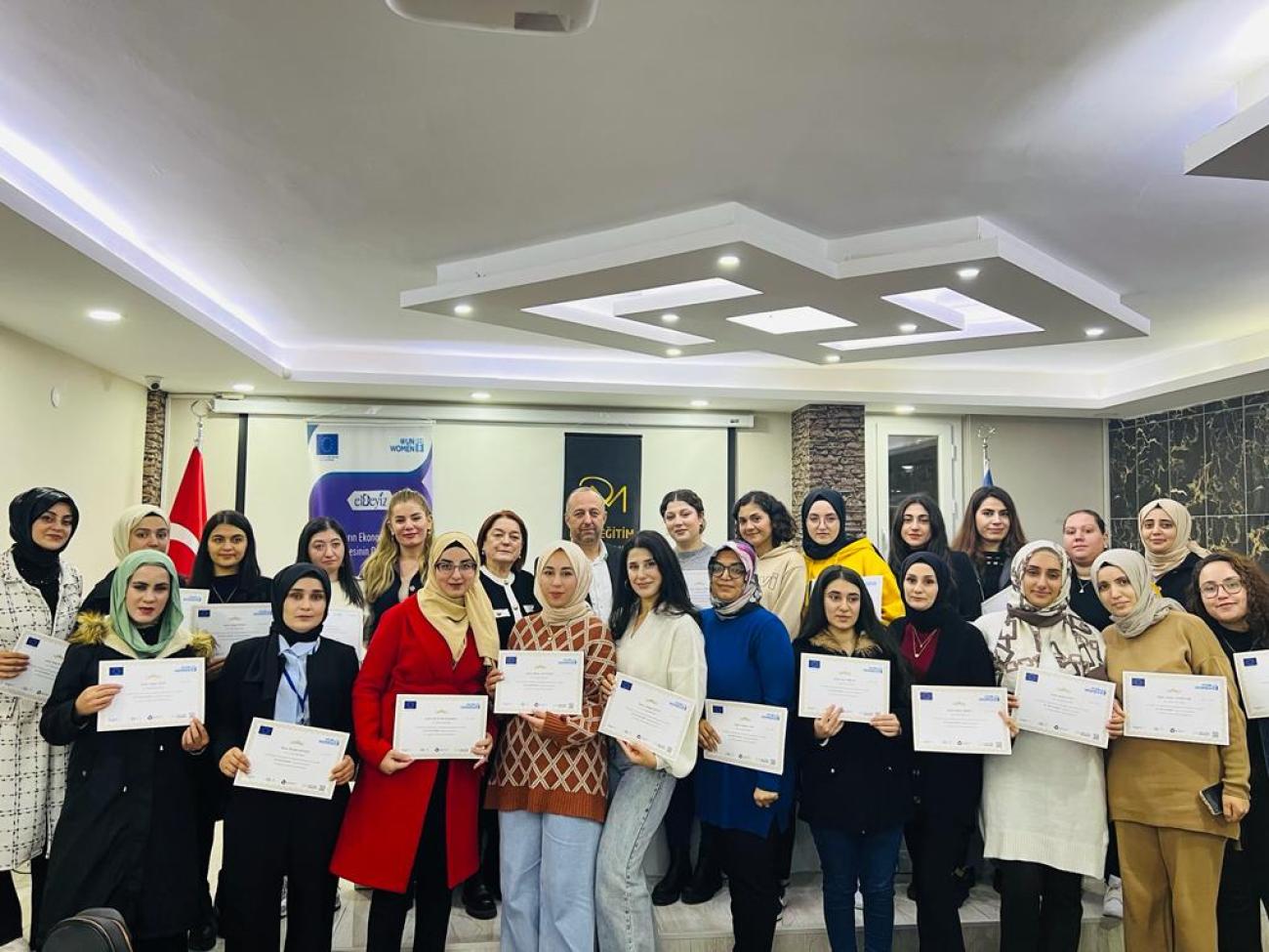 Women after a training pose together with certificates in their hands.