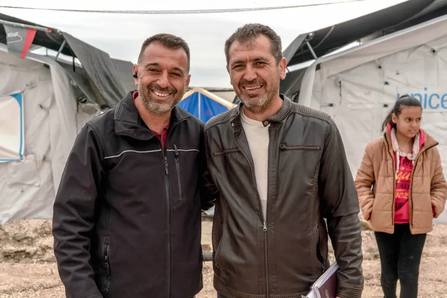 2 teachers smiling to the camera at tent city in Hatay