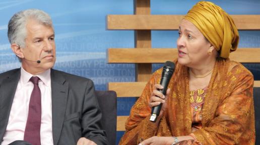 Elinde mikrofon tutan Amina Mohammed bir toplantıda konuşuyor. 