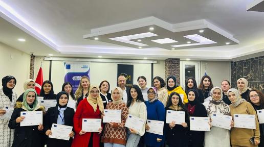 Women after a training pose together with certificates in their hands.